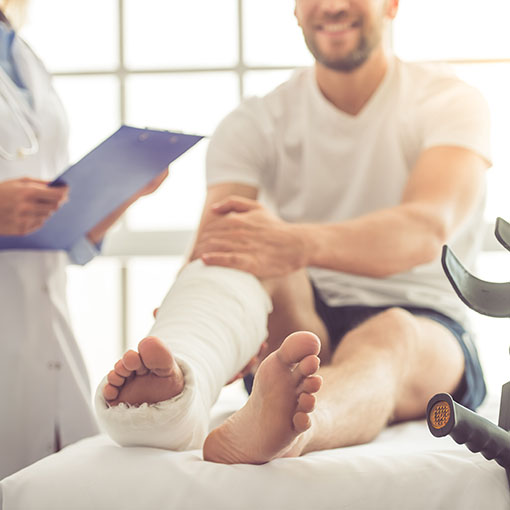 Man with leg cast talking to doctor